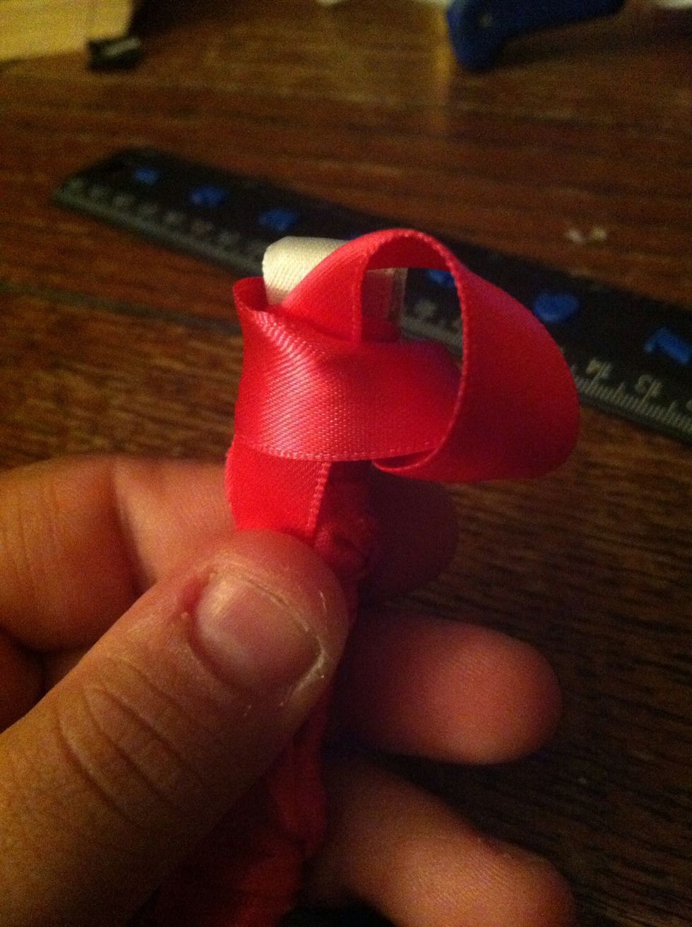 Going around back, slip the end of the ribbon through the back of the stitch.