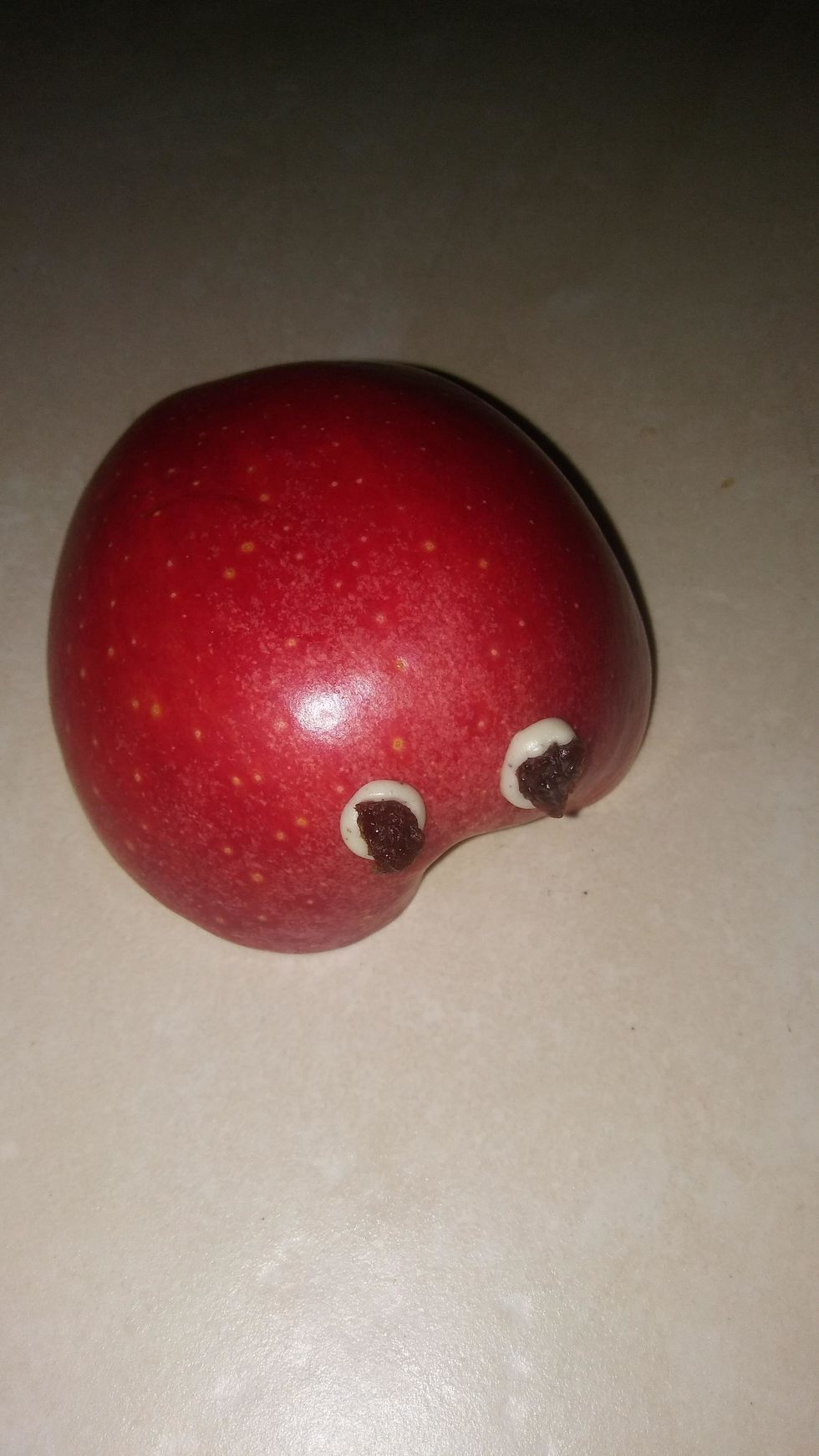 Grab 1 raisin, and cut it in half. Place the raisins in the middle of your "eyes".