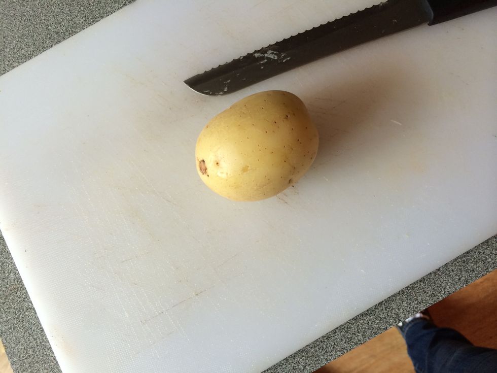 Grab a chopping board, knife and the potato. Cut the potato into thin slices.