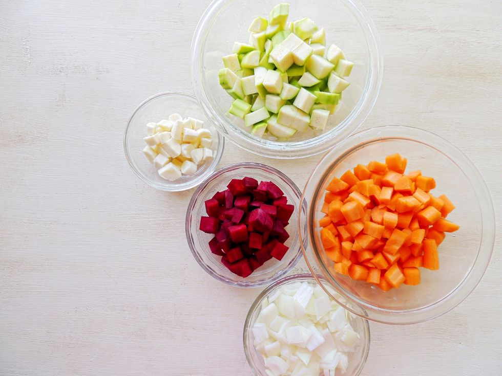 Grab a large bowl and your olive oil. Add a chopped veggie to the bowl and drizzle with oil. Use your hands to toss and cover. You can do each separately or together.