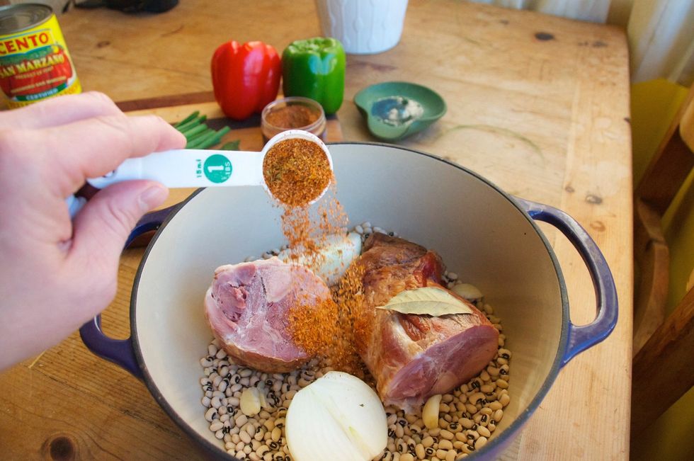 Grab a large dutch oven or cooking pot that will hold the ham hocks, peas and 6 cups of water.  Add the peas, ham hocks, bay leaf, 1 onion - halved, and 1 tablespoon of Smokin' Chipotle Seasoning.