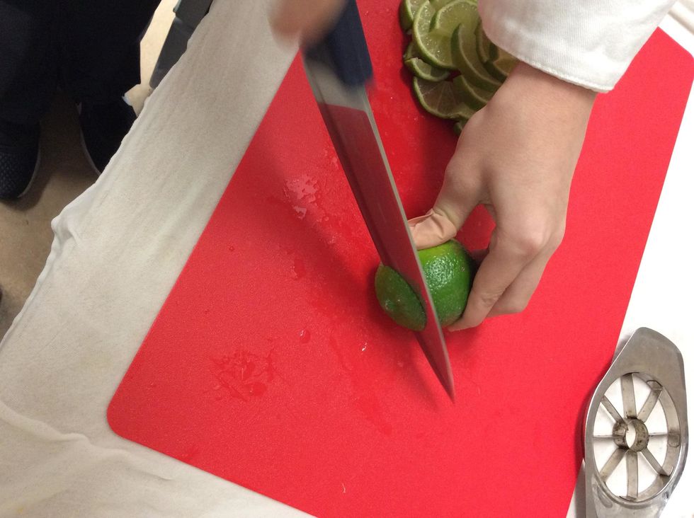 Grab a lemon lime and cut of the edges of the lemon lime that we don't need.