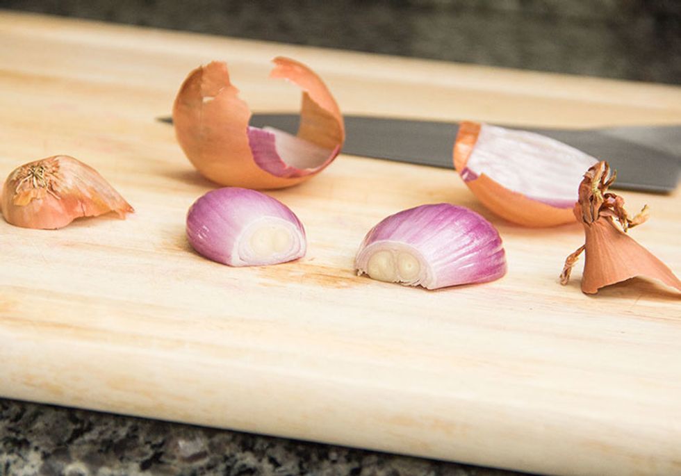Grab a shallot and slice off both ends. Cut the shallot in half lengthwise and peel off the skin.