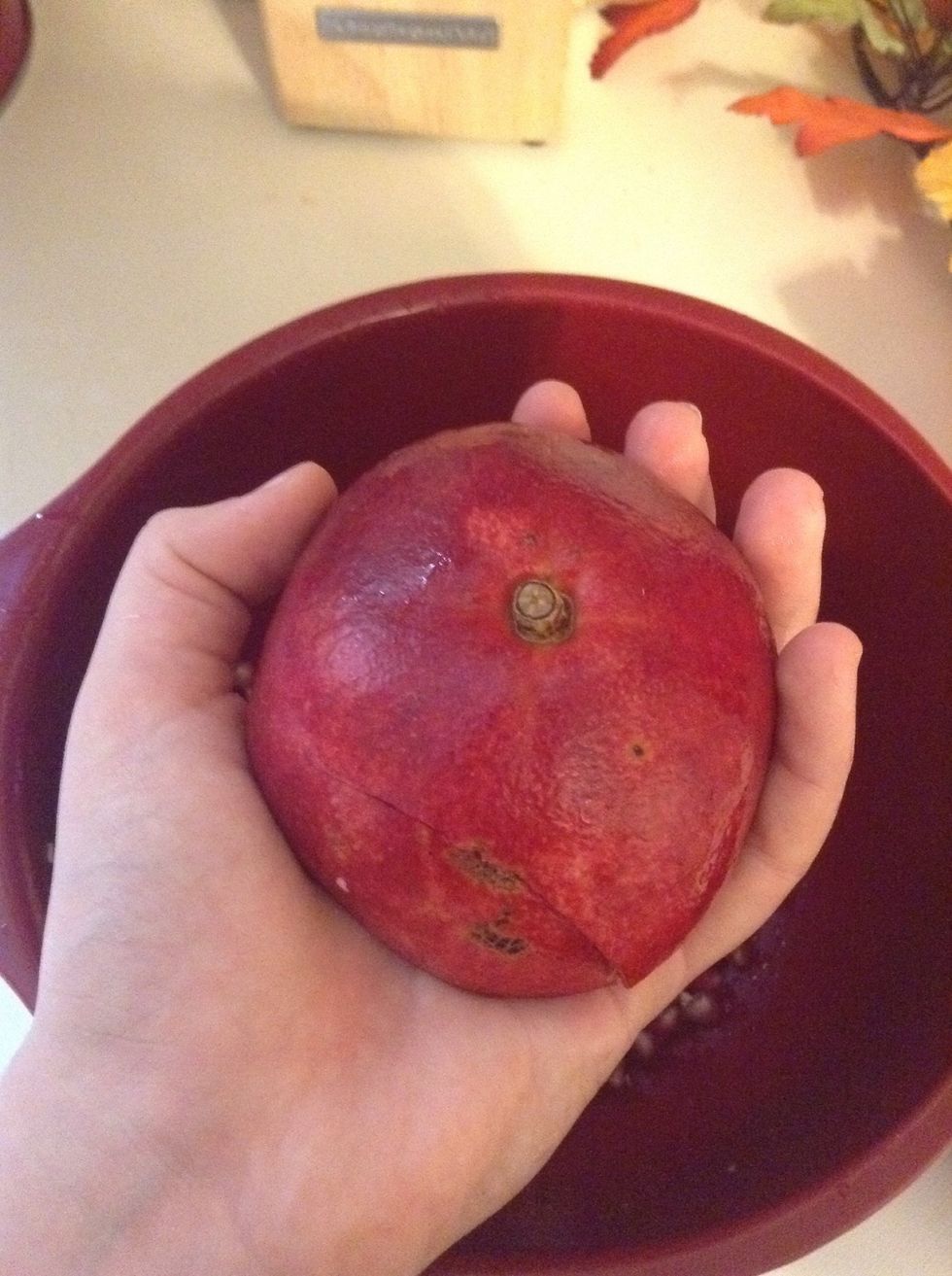Grab a small bowl and hold your pomegranate face down, grab a wooden spoon or anything really and start to WACK the pomegranate! You're going to have to hit it pretty hard.