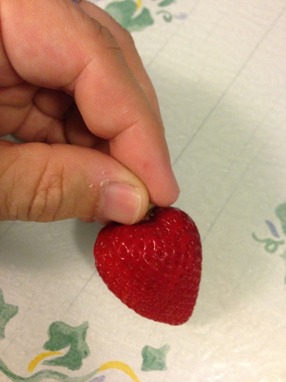 Grab all of the leaves (calyx) together and pull them off.