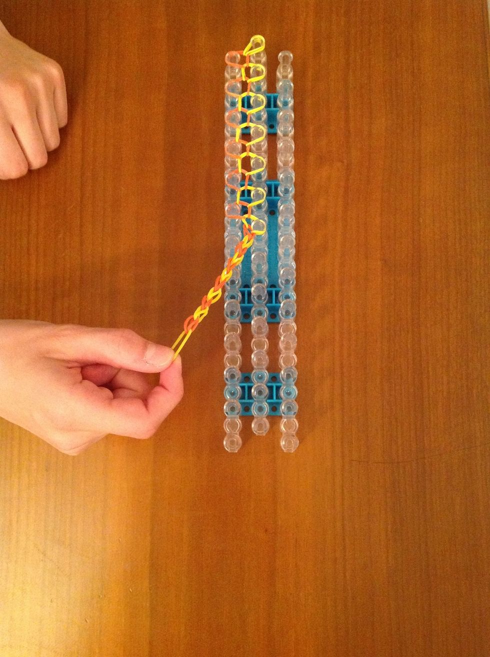 Grab hold of the rubber bands on the two ends of the loom and take off all the rubber bands.