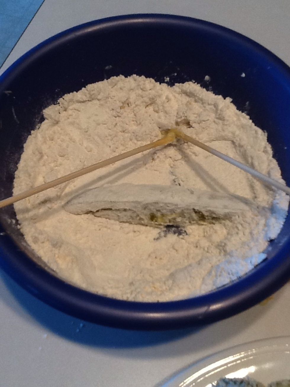 Grab one pickle spear out of the jar and coat with flour.