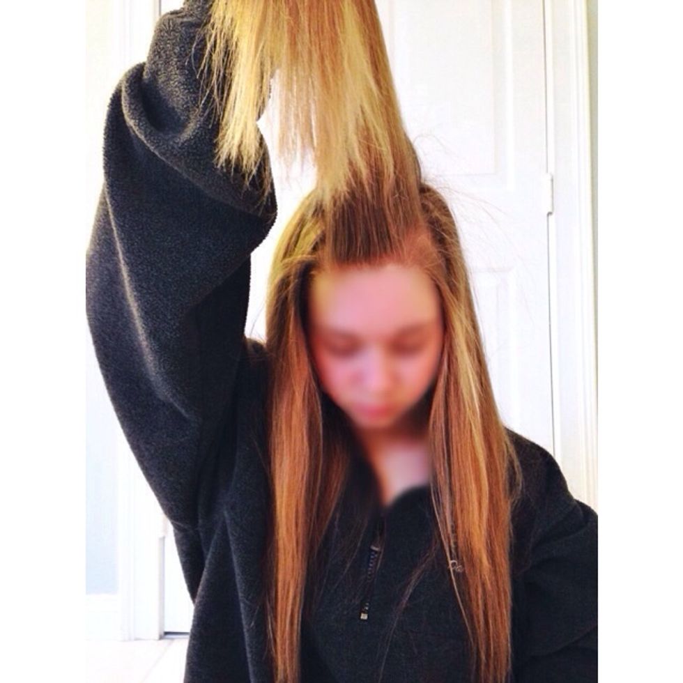Grab pieces of hair from each side of the front of your head. Pull them together, and up above your head as shown in the picture.