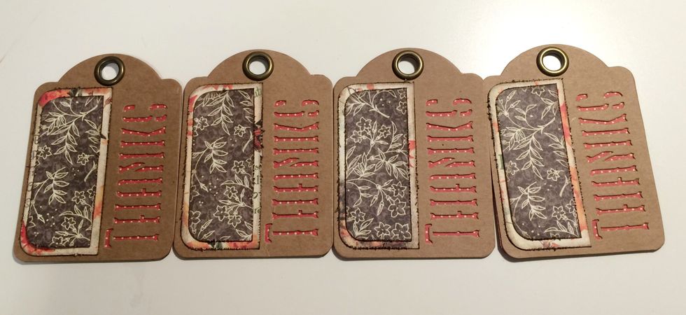 Grab the 4 tags with red dots showing through the thanks. Adhere the large fall piece to the left of thanks on each tag. Adhere the small brown floral piece overtop of fall paper piece on each tag.