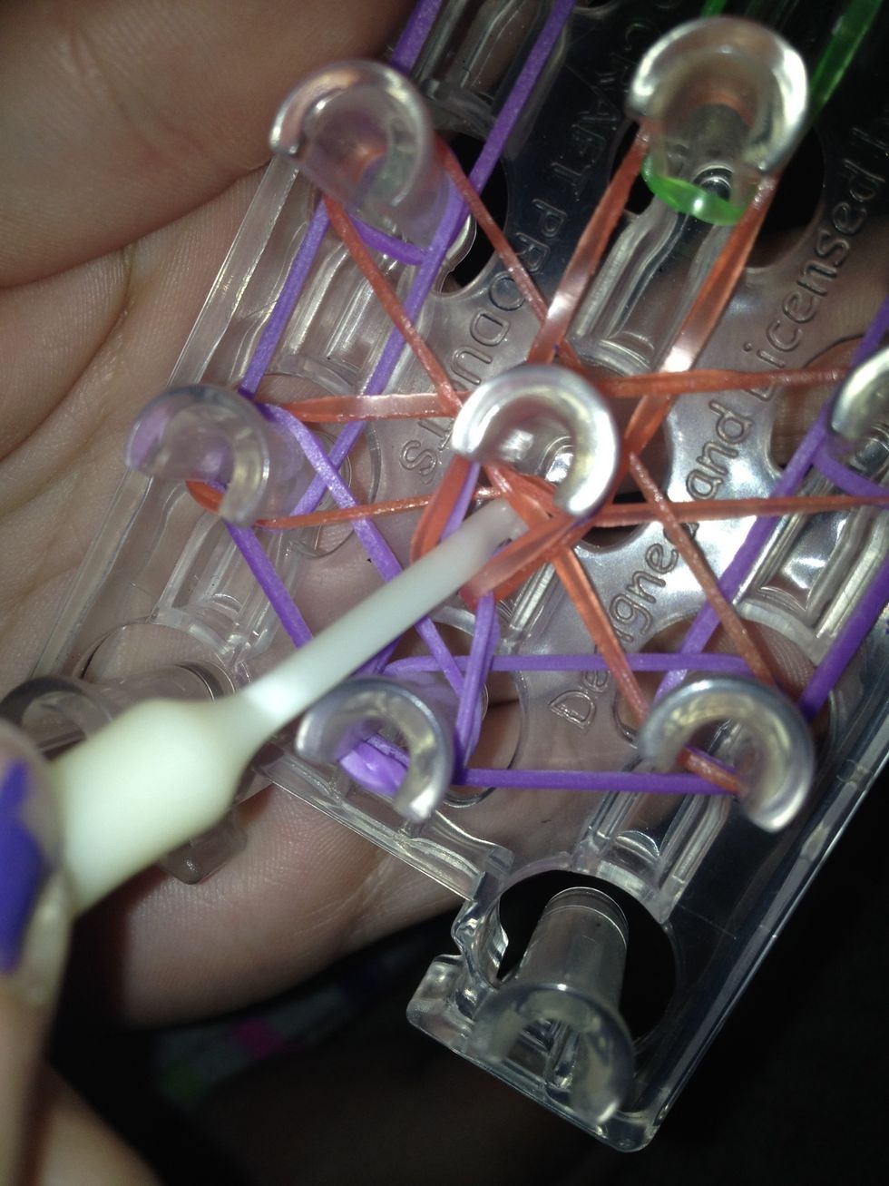 Grab the band and pull it to the peg it leads to