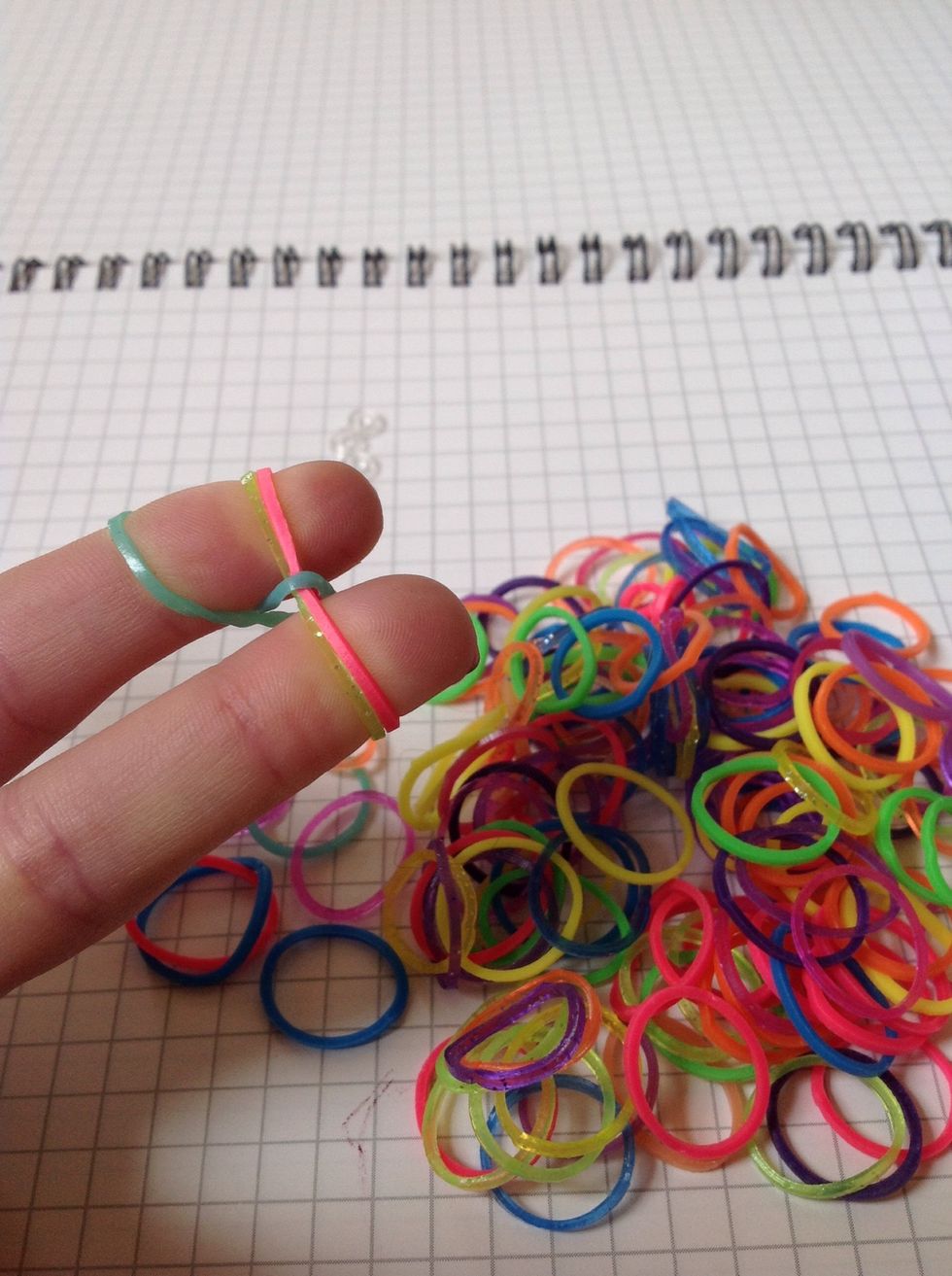 Grab the bottom 1 ( the one that u twisted ) and bring it up over the top of all of the bands.