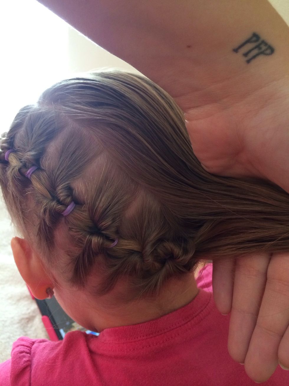 Grab the end of the fake braid and the other side of the hair