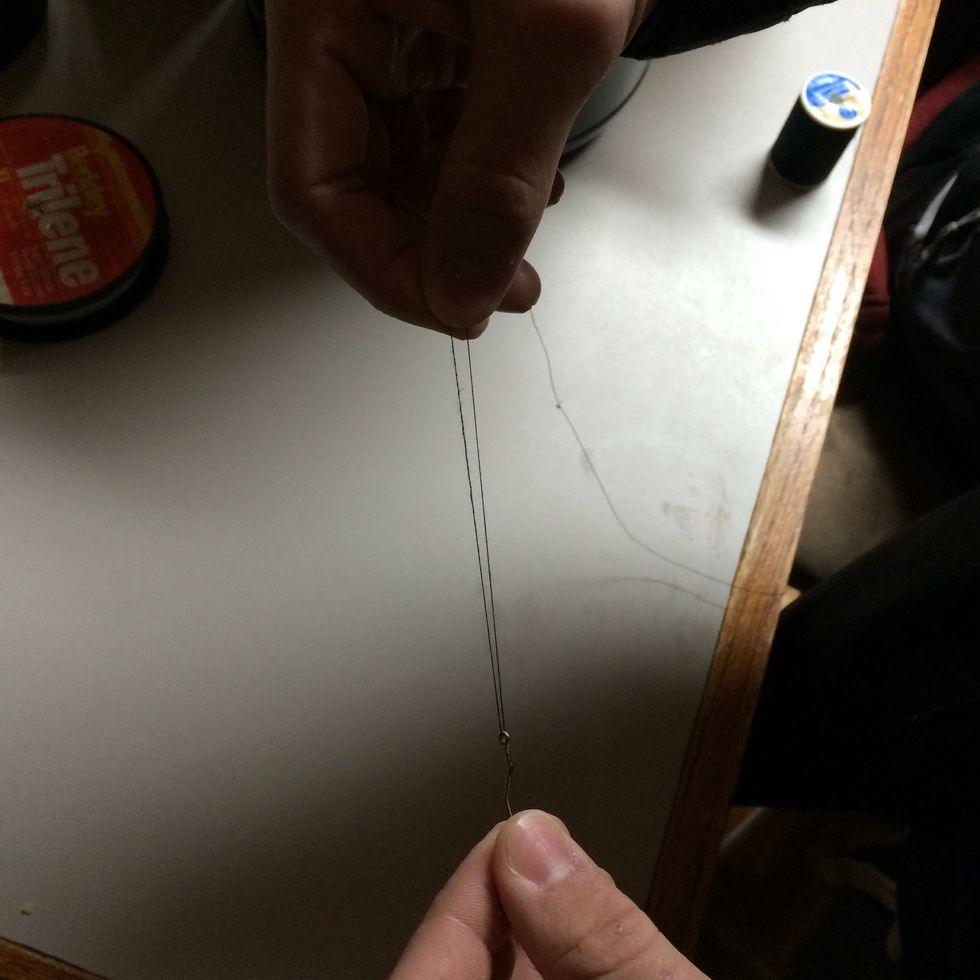 Grab the end of the fishing line that you put through the eye of the hook and pull it up towards the other line 3 inches