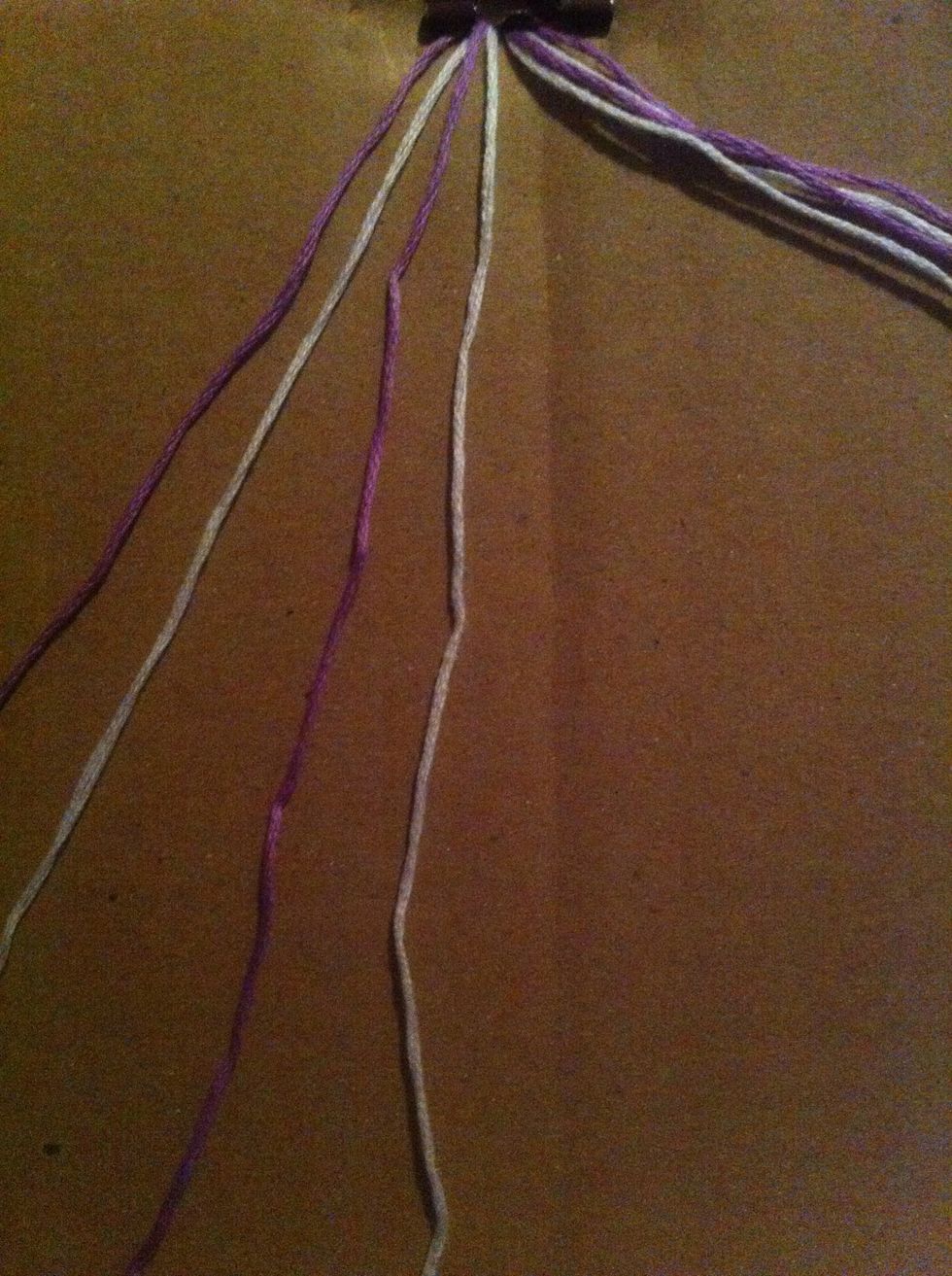 Grab the first 4 leftmost strings. With the first string (in this case, purple), make a forward knot over the next string (itc, white). Repeat with the other strings.