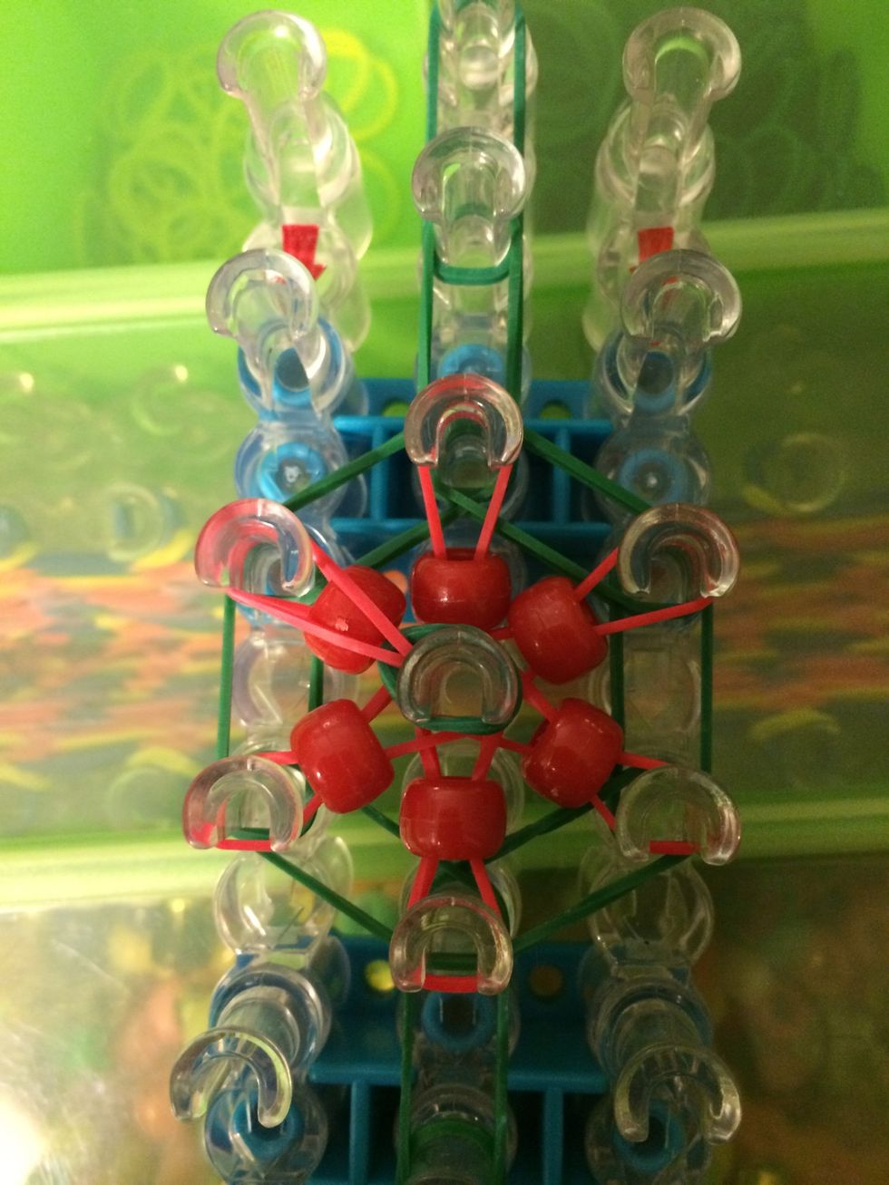 Grab the first band on top and loop it to the left. Flow the counter-clockwise motion and loop the rest of the bands.