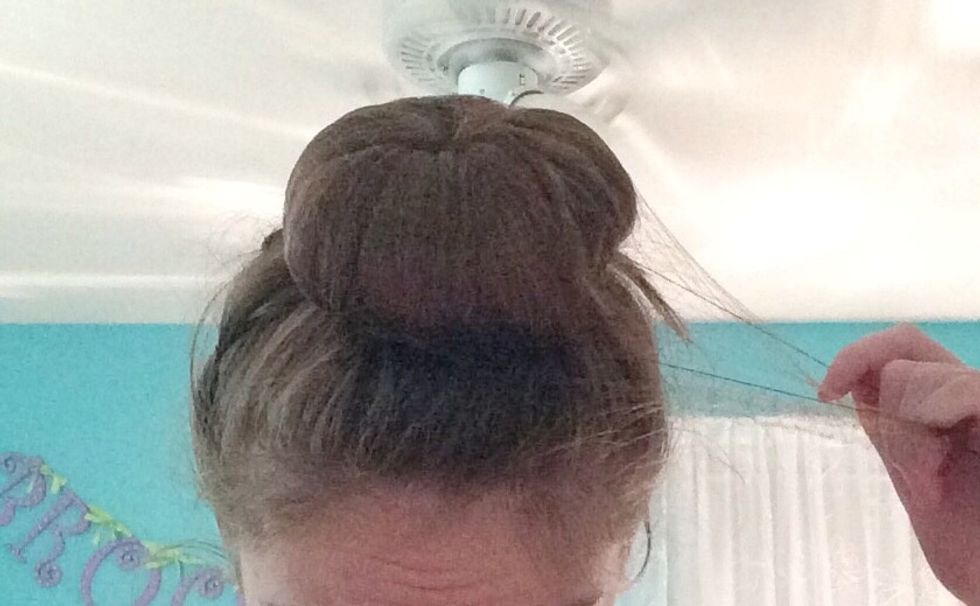 Grab the hair net and pull one side of the hair net on top of the bun. Then twist the rest of the hair net around the bun.