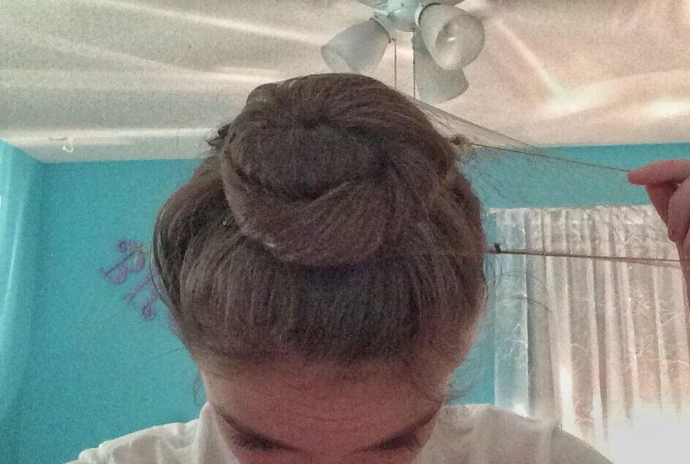 Grab the hair net and pull one side of the hair net on top of the bun.