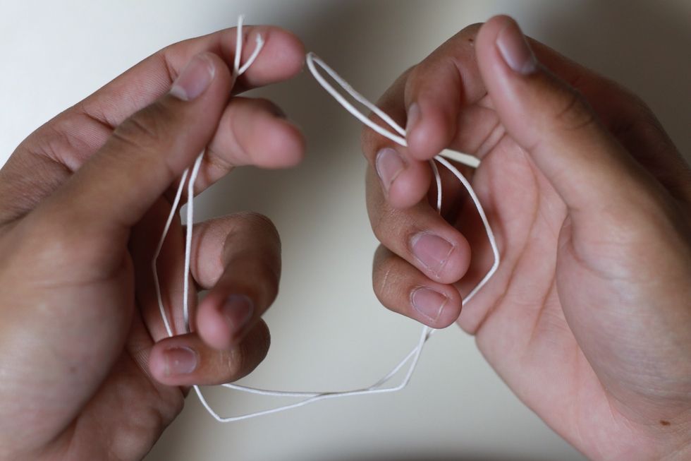 Grab the other cord and fold it in half to find the middle