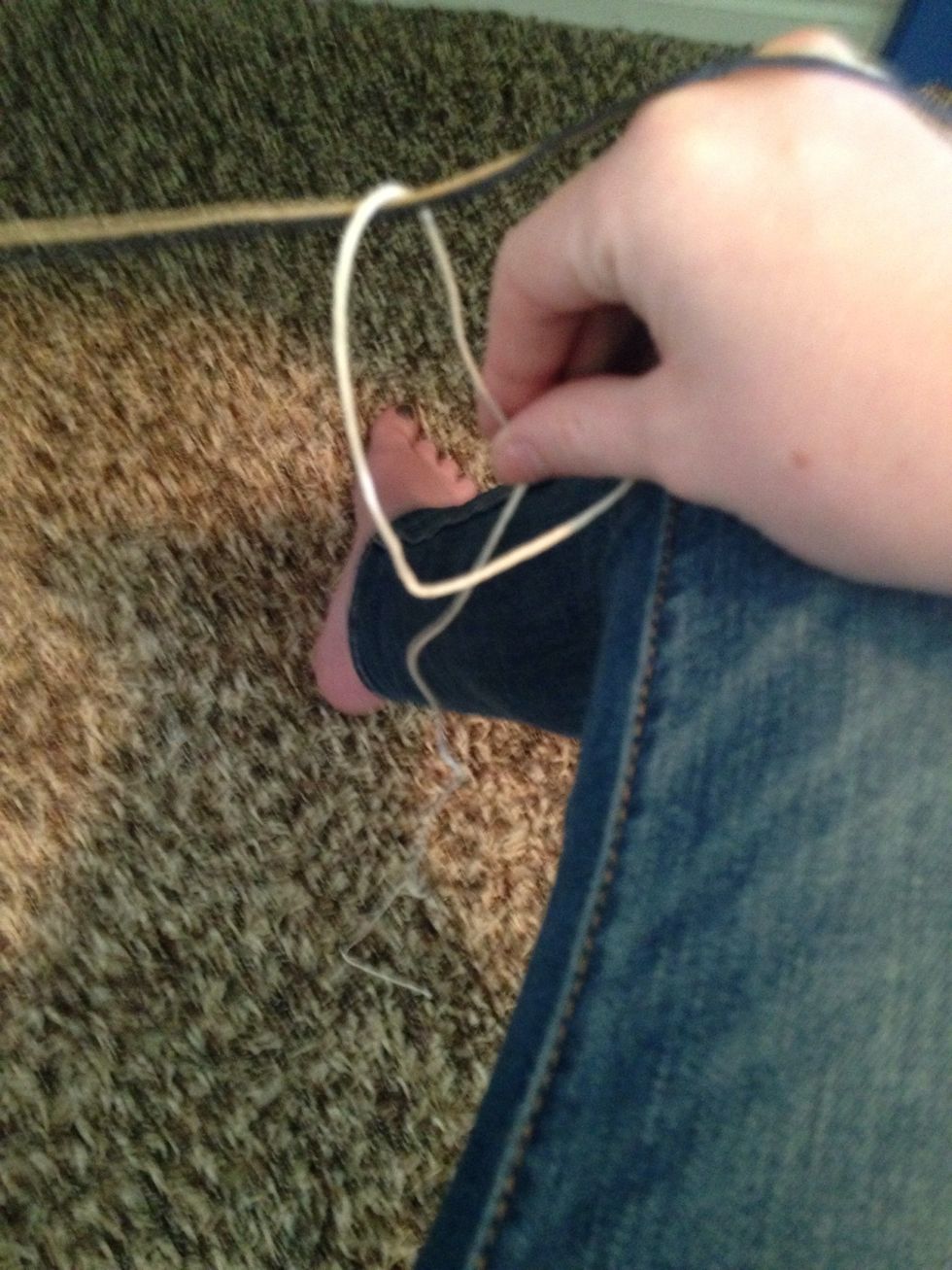 Grab the rest of the string on the other side. Remember to keep the other strings tight!