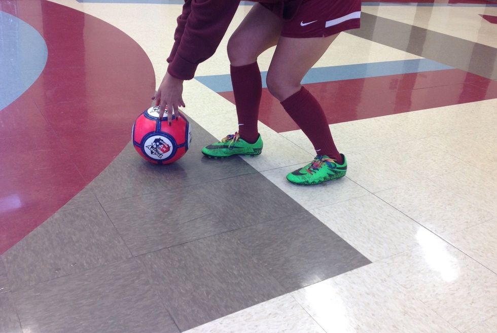 Grab the soccer ball and set it on the ground/floor