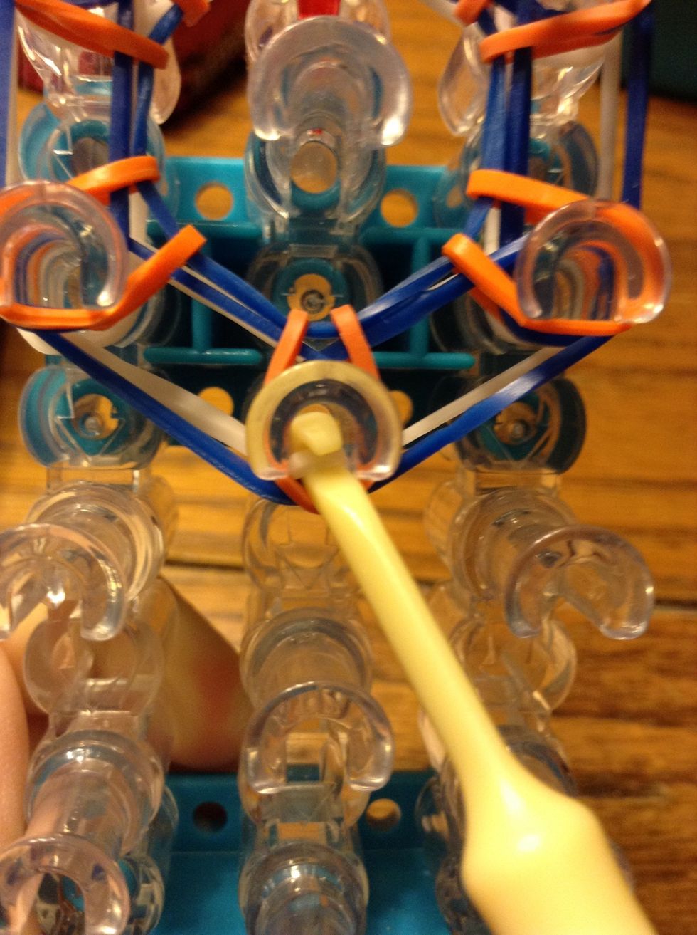 Grab the top whites band on the bottom peg and loop it on to the one on the left.