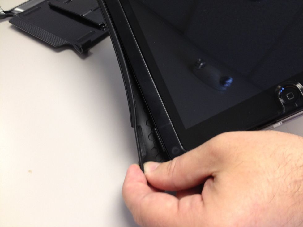 Grab the "trim piece" and start working it around the plastic frame. There are grooves to secure the protective covering into place. It's not easy is it? Press into place and rotate. Repeat.