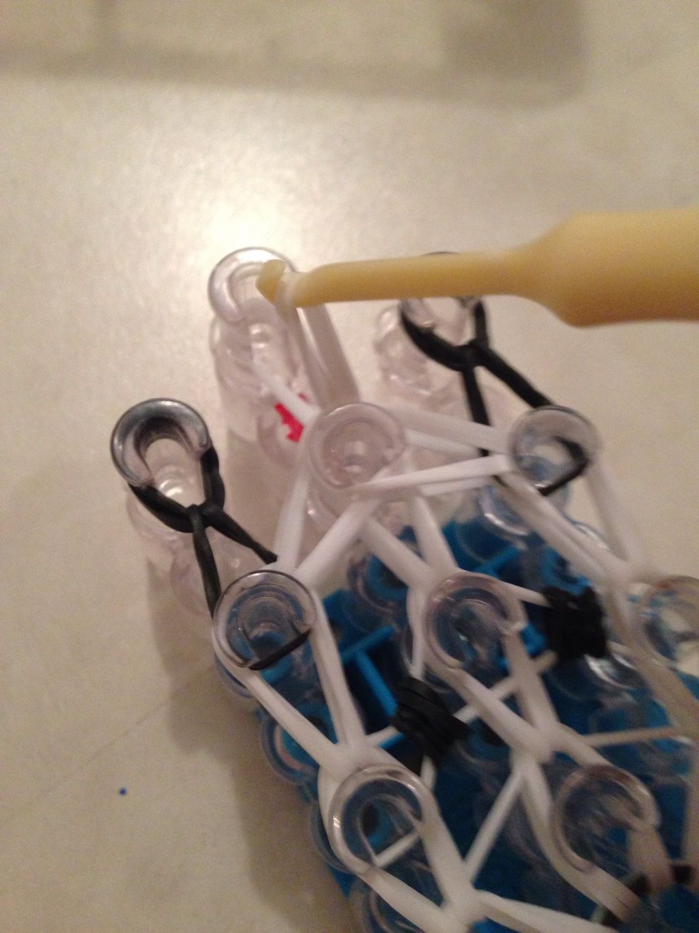 Grab the very top white bands and loop them up like so