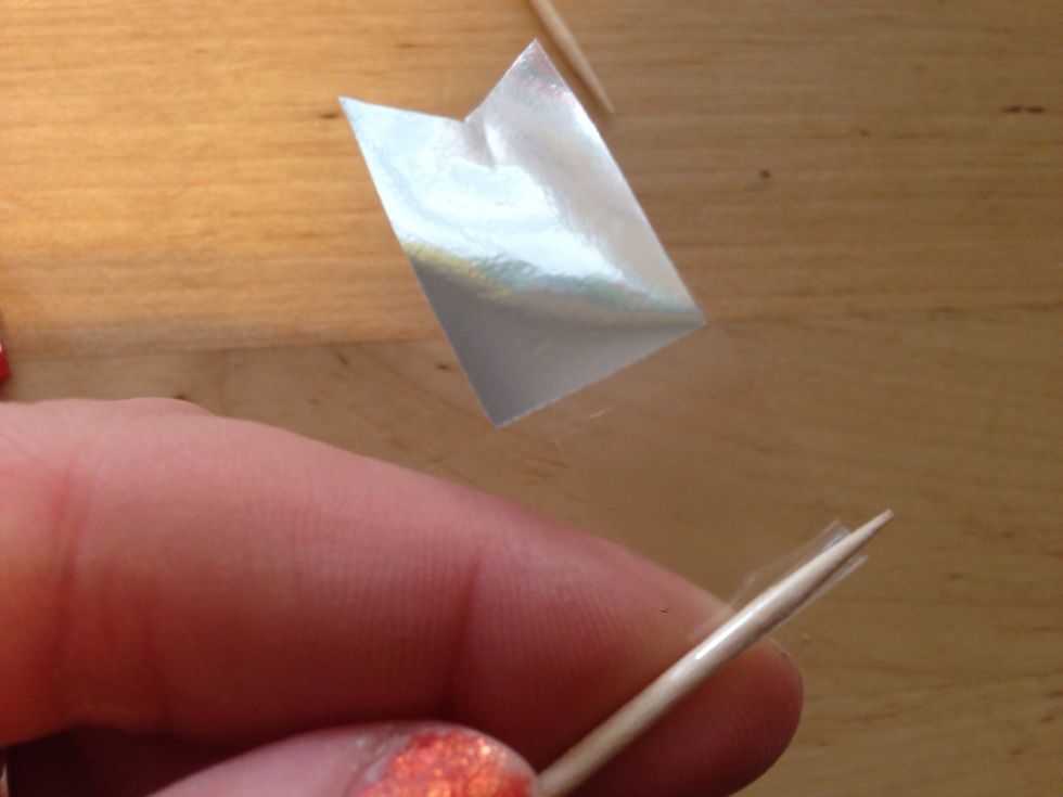 Grab Toothpick and start wrapping the tail end of your tape around the toothpick until it has wrapped until end of tape, so flag flies freely from toothpick.