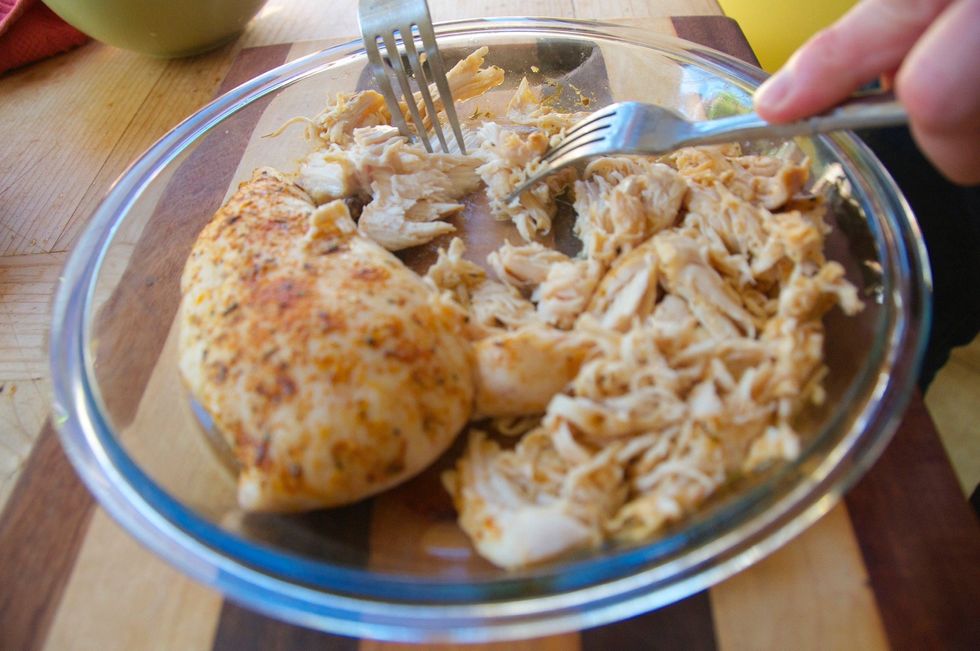 Grab two forks and begin to shred the chicken.  Do this while it's still hot and it's a lot easier.  Hold the breast w/ one for and pull it apart with the other, in a scraping motion.