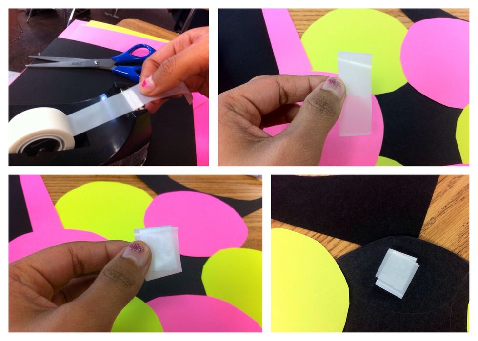 Grab two inches of tape. Fold the top of it towards you and the bottom away from you. The bottom should overlap the sticky side of the tape like shown in the picture. Tape it down on the black paper