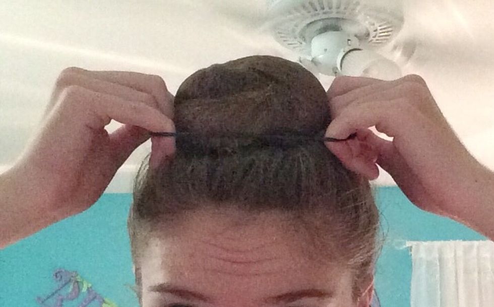 Grab your last pony tail, and pull it over the bun.