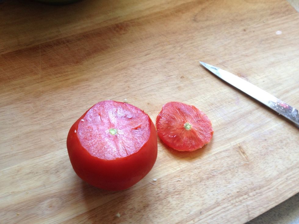 Grab your luscious tomato and cut off the top portion to make it easier to cut. Place cut part down