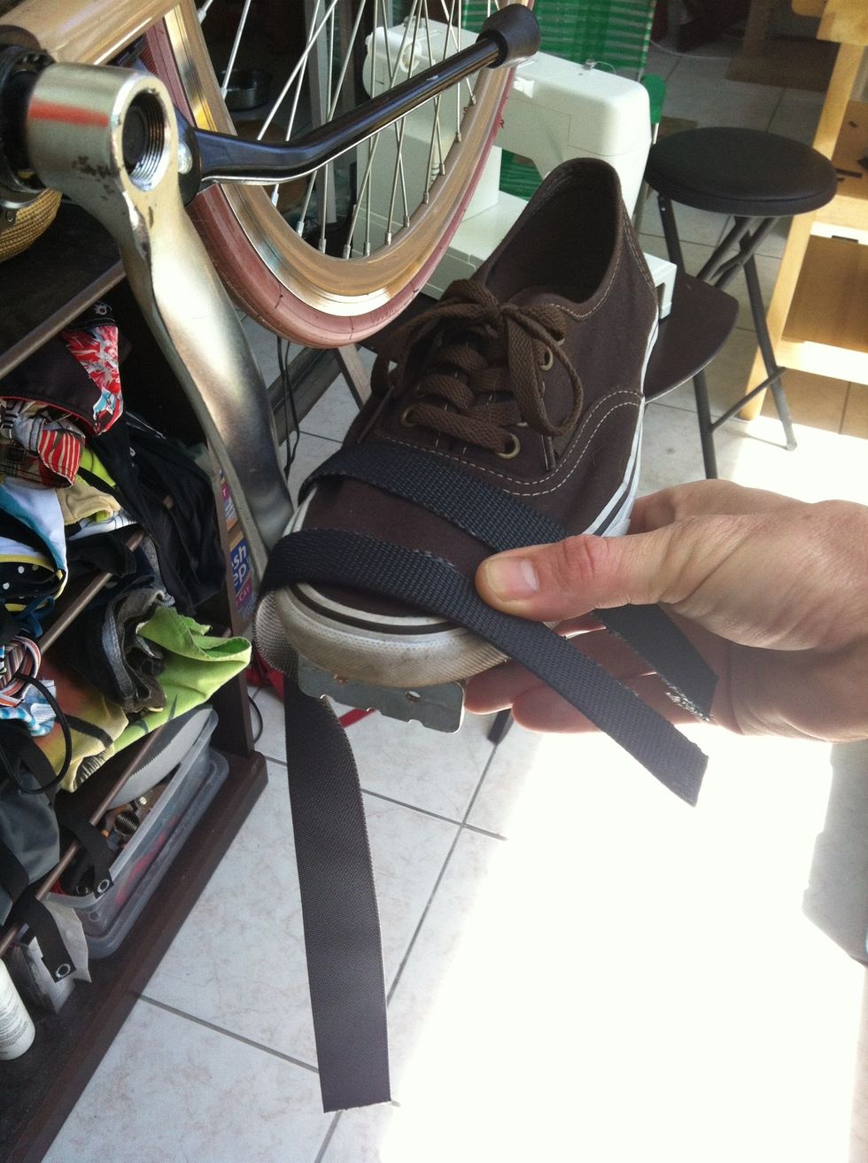Grab your riding shoe and wrap the strap under, around the pedal post, and over your shoe. Mark at outside of pedal.