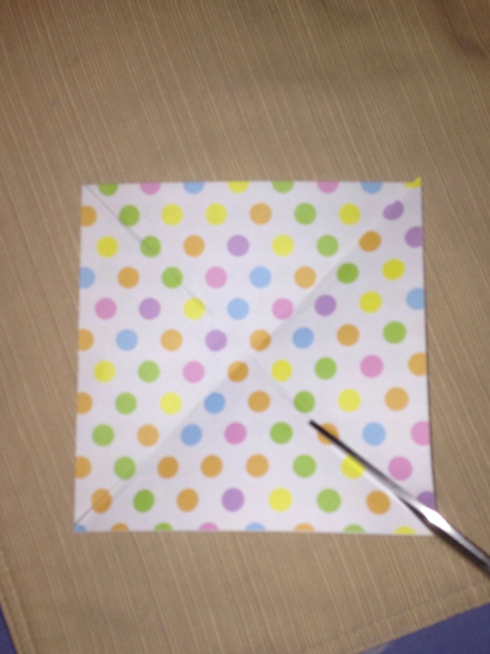 Grab your scissors and cut on the creased line , stopping about 2/3 of the way. Repeat on the other 3 creased lines.