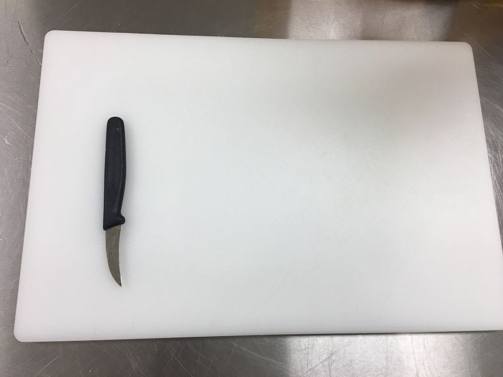 Grab your tourne knife and place it on the cutting board.