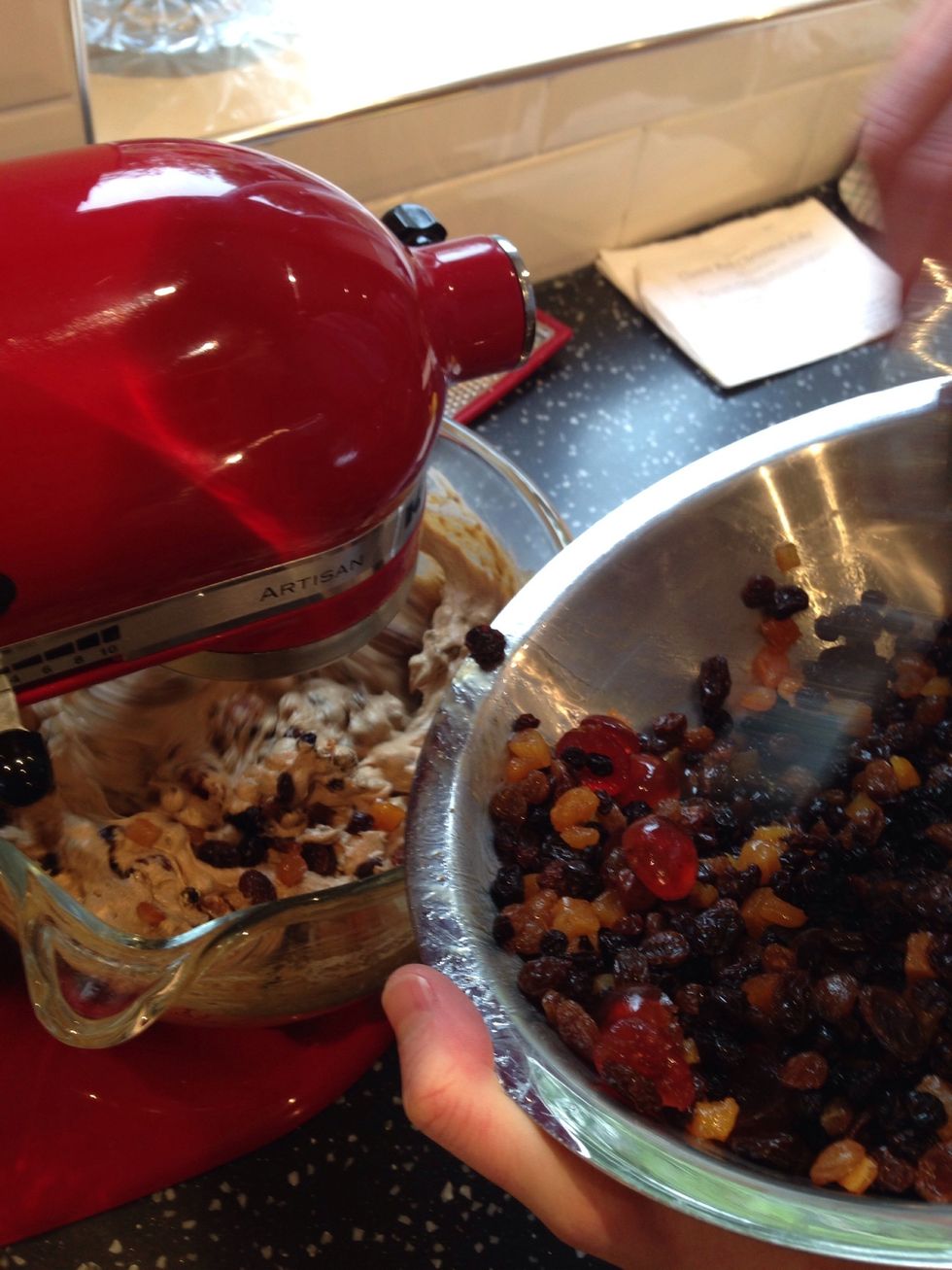 Gradually fold in the soaked fruit to the cake batter and ensure it is mixed thoroughly