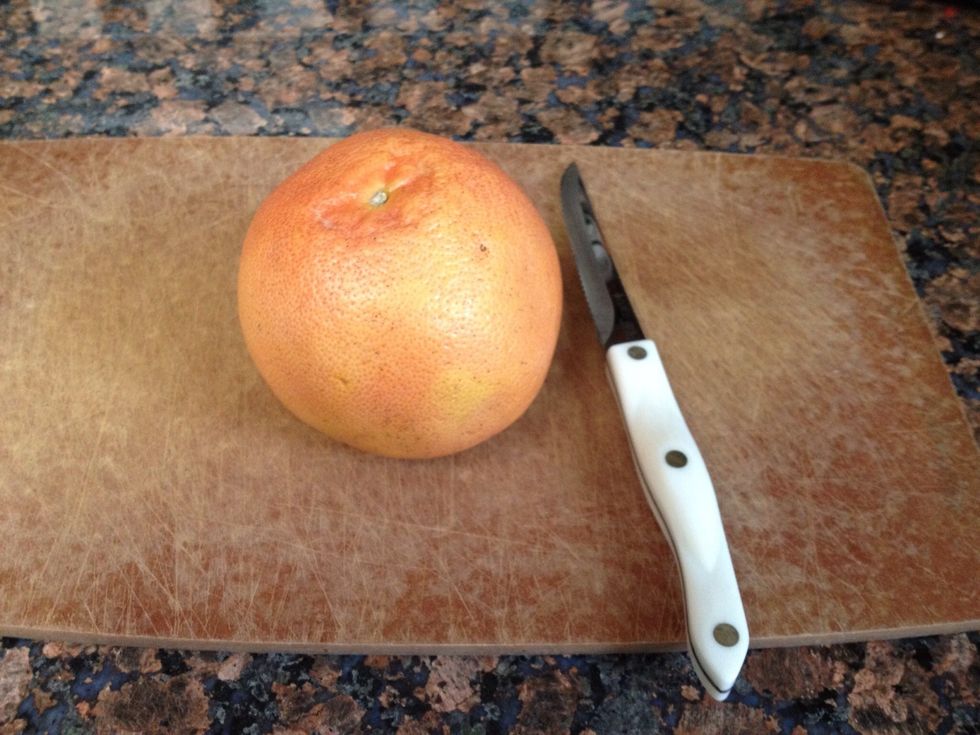Grapefruit , small knife, cutting board