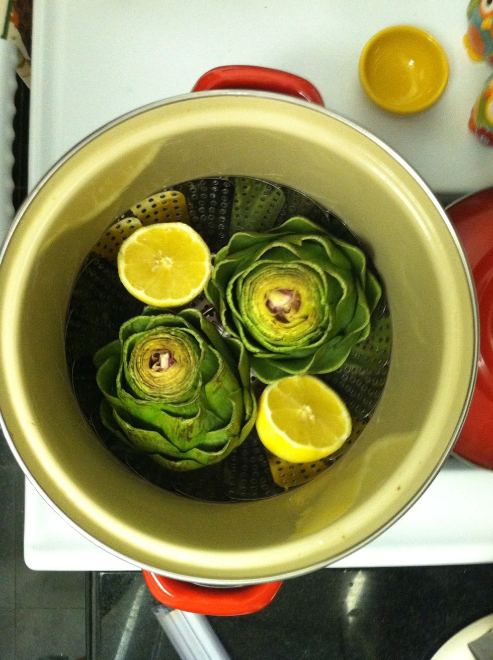 Grate 1 tsp lemon zest into a food processor.  Halve the lemon.  Steam the lemon halves and artichokes in a saucepan until a paring knife inserted into a stem meets little resistance, 25-35 minutes.