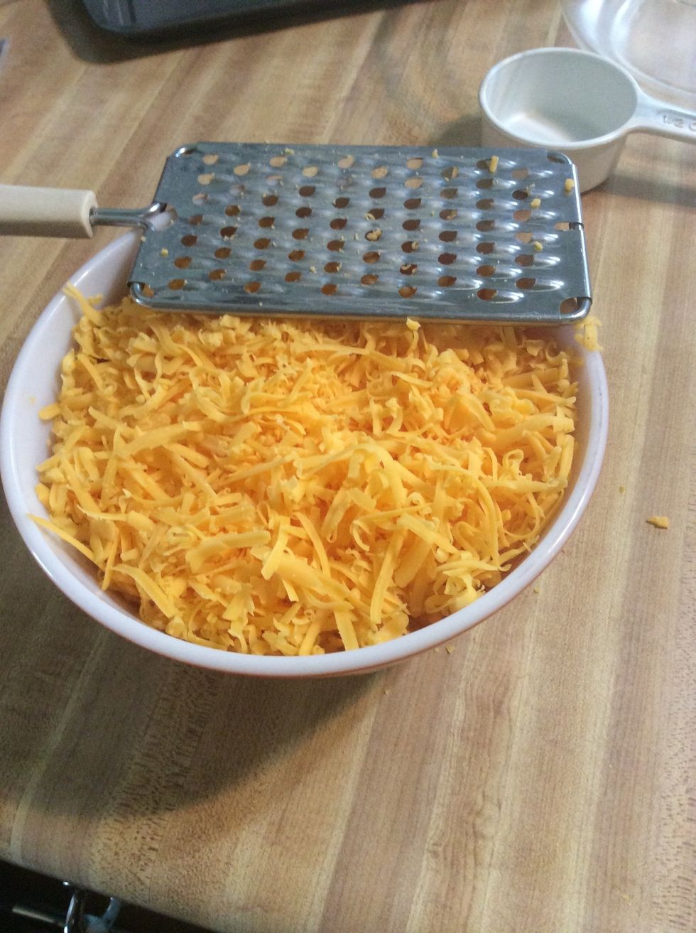 Grate all 16 ounces of cheese into one of the large bowls.