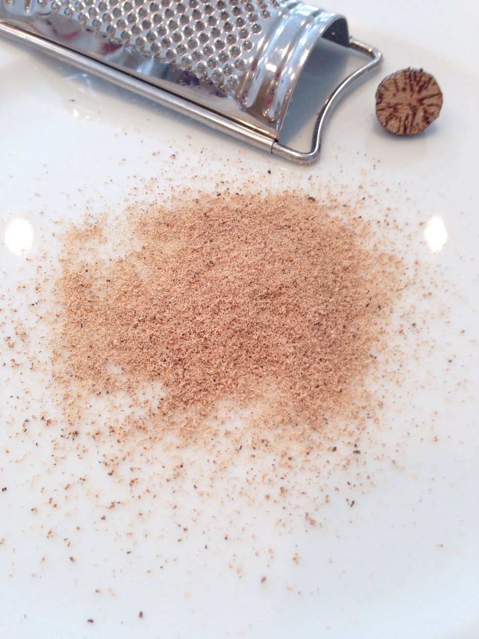 Grate it onto a plate and scoot it into the measuring spoon. Or, grate it on paper then pour into the spoon. Either way, it will get everywhere, but you won't care because it smells so good.