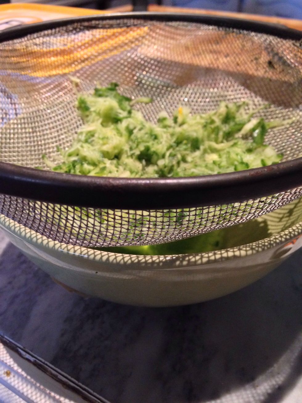 Grate the cucumber and place in a sieve over a bowl, sprinkle with salt and leave to drain. The salt draws the moisture out preventing a runny tzatziki later.