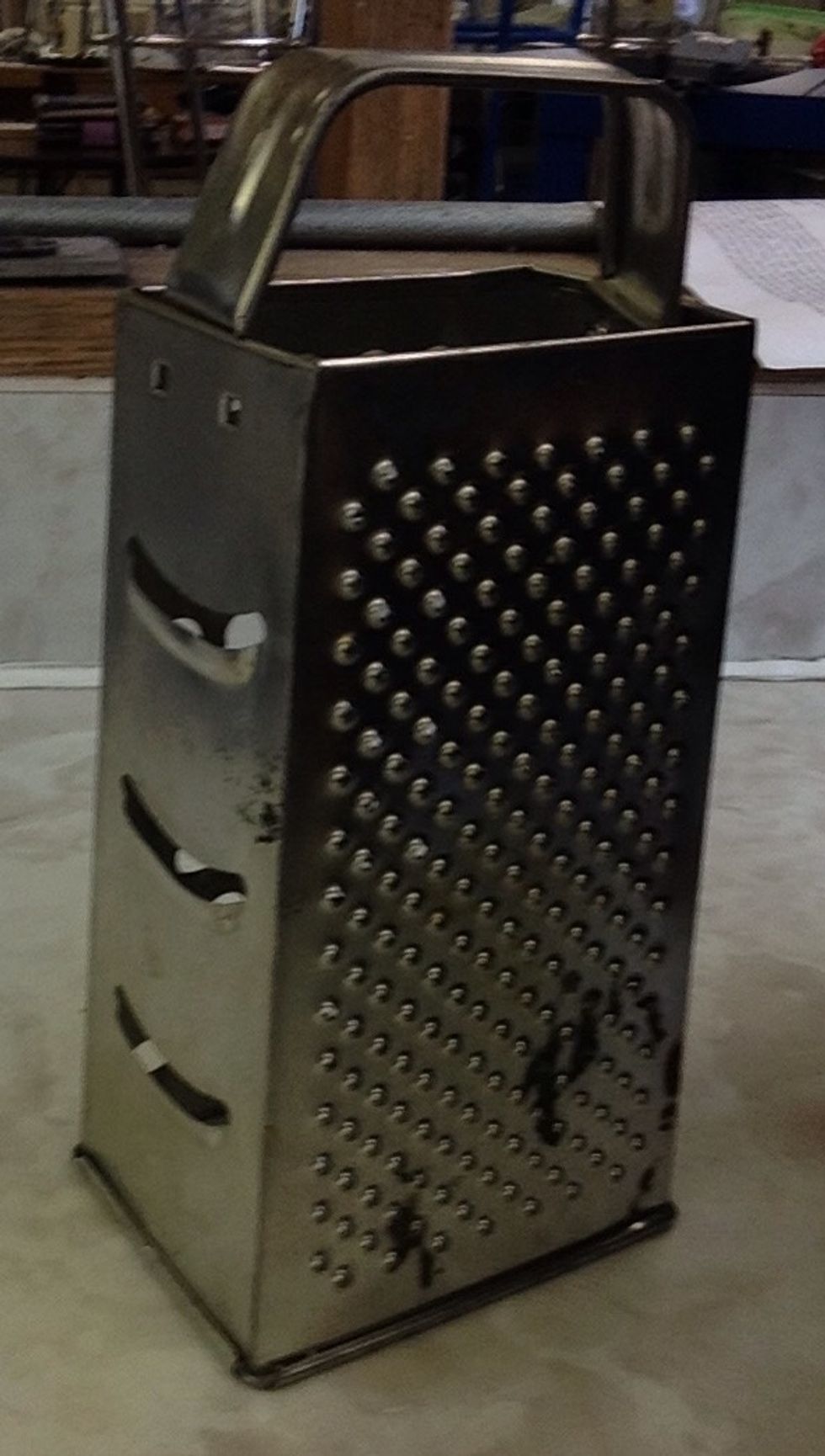 Grater. Used for shredding cheese. I can shred cheese using a grater.