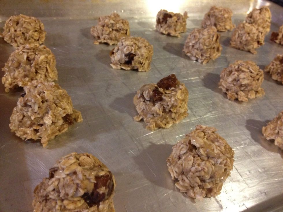 Grease a cookie sheet generously. If you have an icecream scoop, scoop out 16 cookies. If not, divide the cookie mix evenly and shape into balls with your hands.