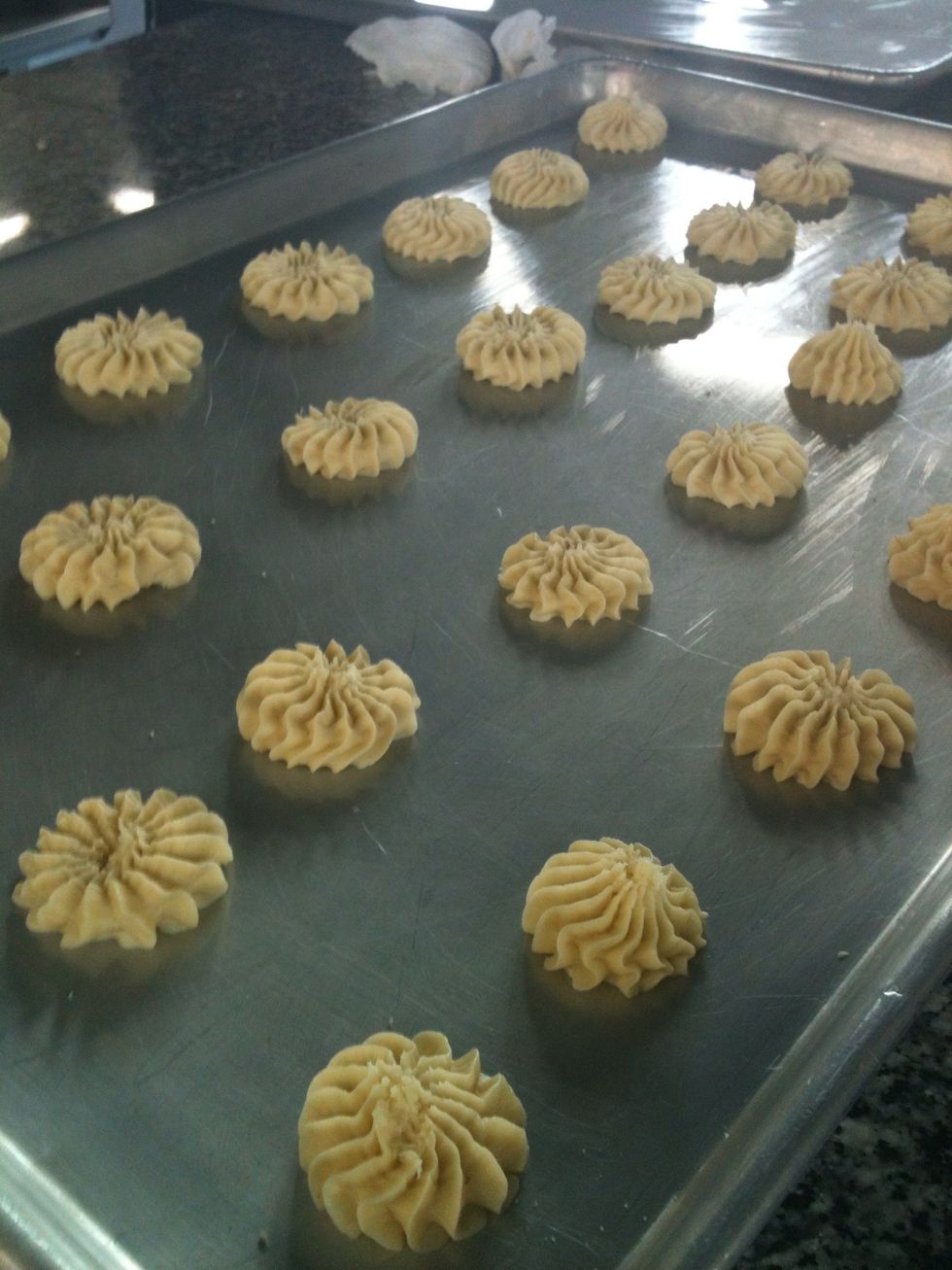Grease the pan with margarine, and with a pastry bag make the cookies.