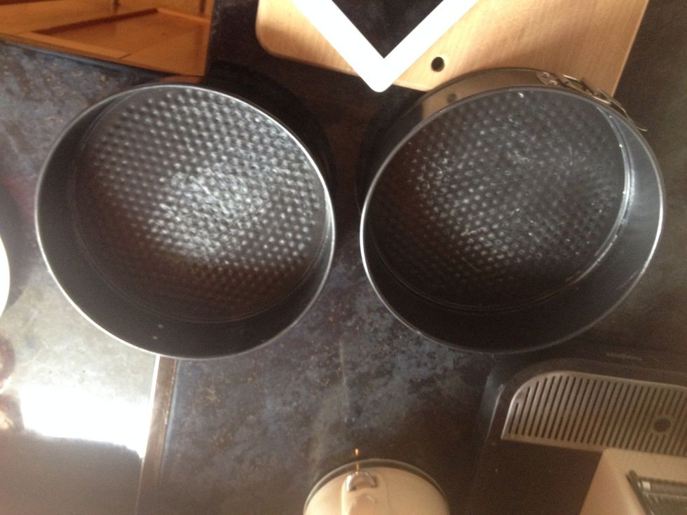 Grease the two baking tins