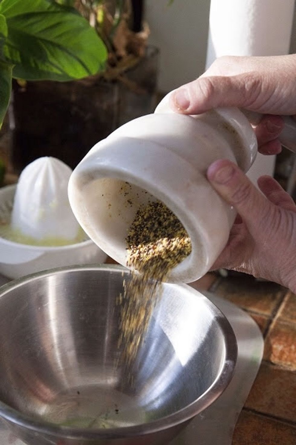 Grind the mustard seeds in a spice grinder or mortar and pestle. Pour them into a non reactive (stainless steel, glass, or ceramic ) type bowl.
