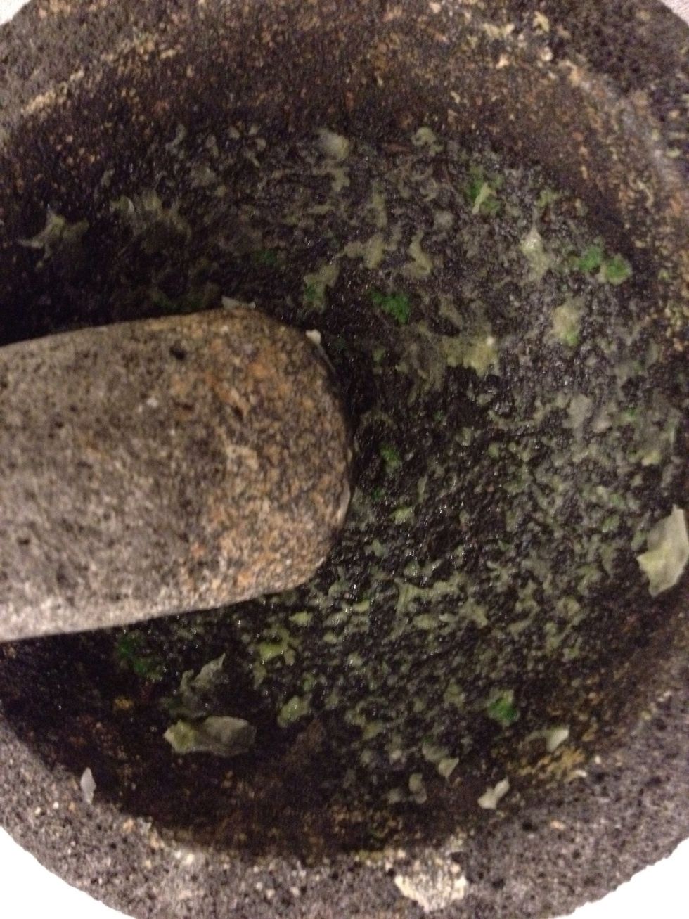 Grind the onion, cilantro and jalape\u00f1o into a paste. This will season the molcajete.
