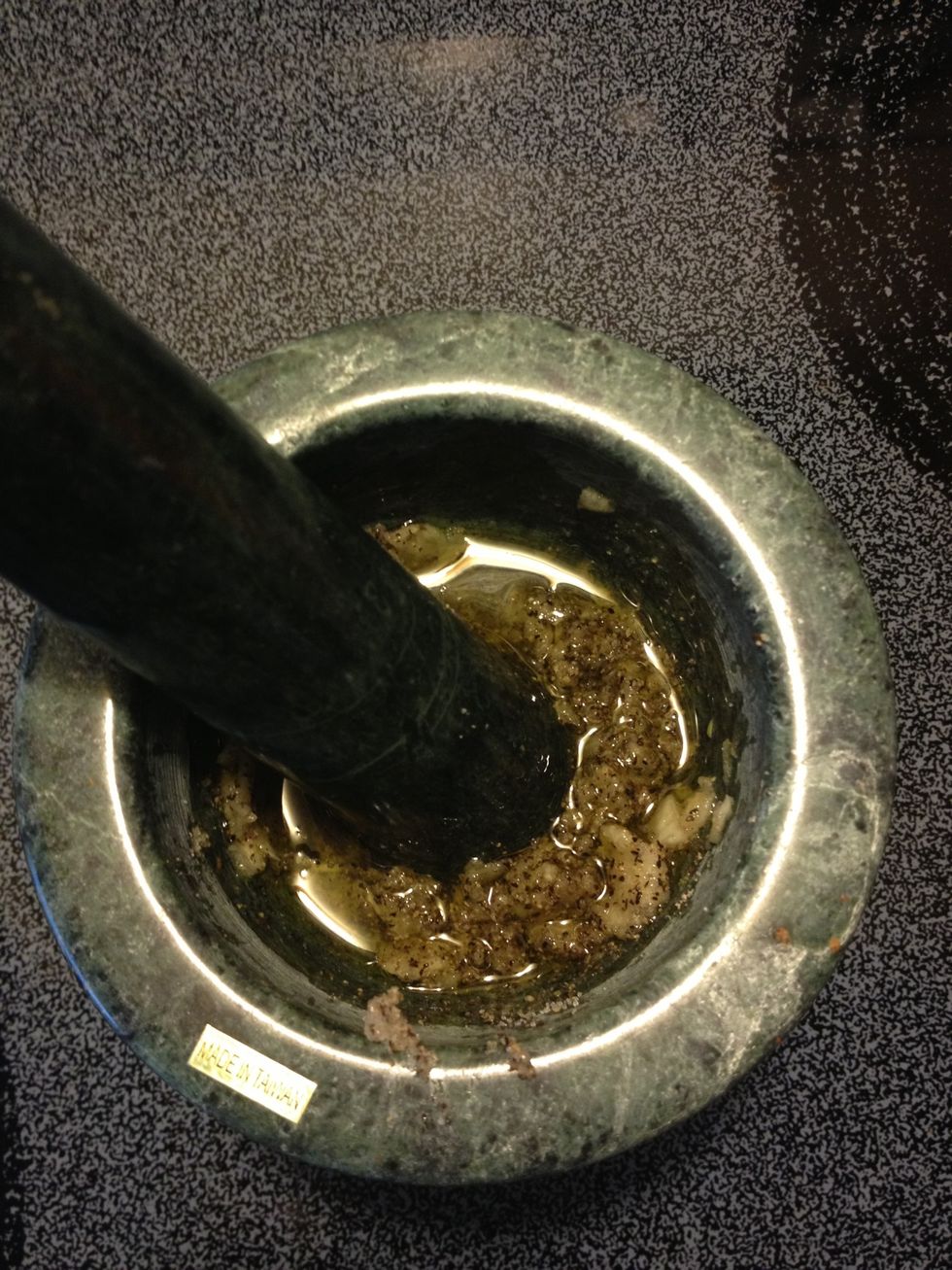 Ground garlic, salt, black pepper and cumin until coarsely ground. Add 1 tbsp olive oil. Don't add while grinding.