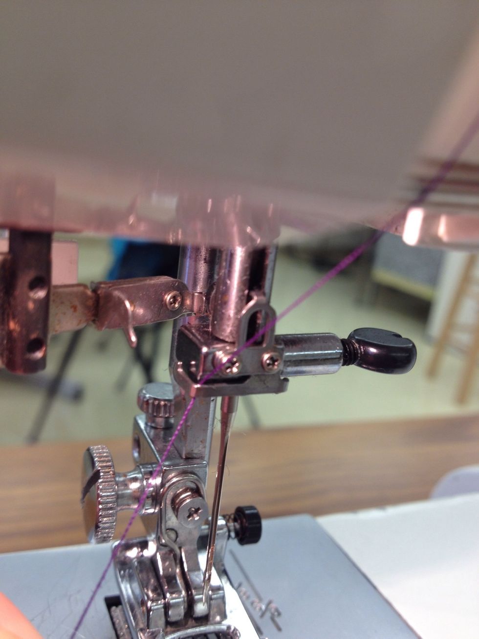 Guide the thread behind the needle bar thread guide.