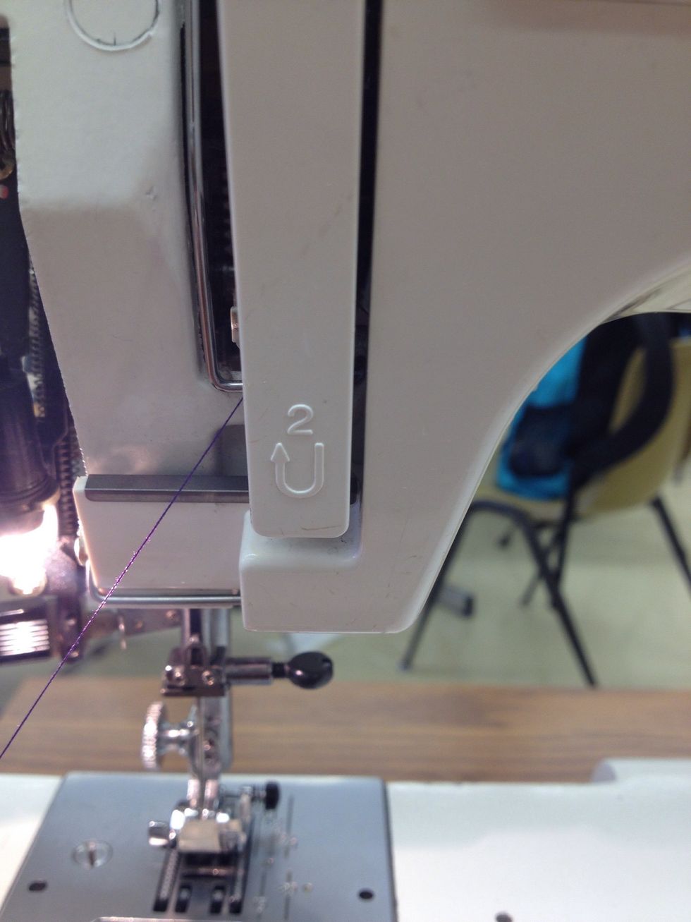 Guide the thread down the right side of the thread guide plate and around the bottom.